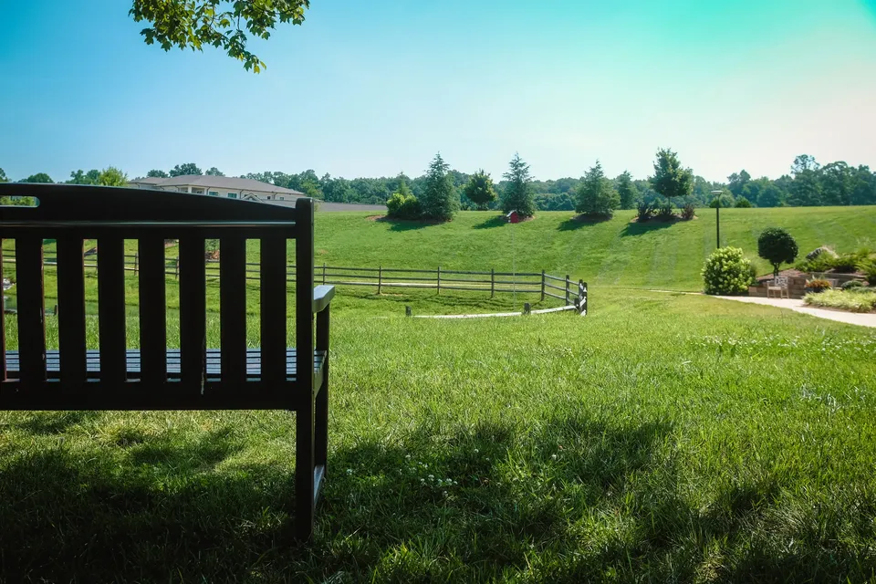 Maintained commercial grounds with mowed turf, fencing, and young trees.