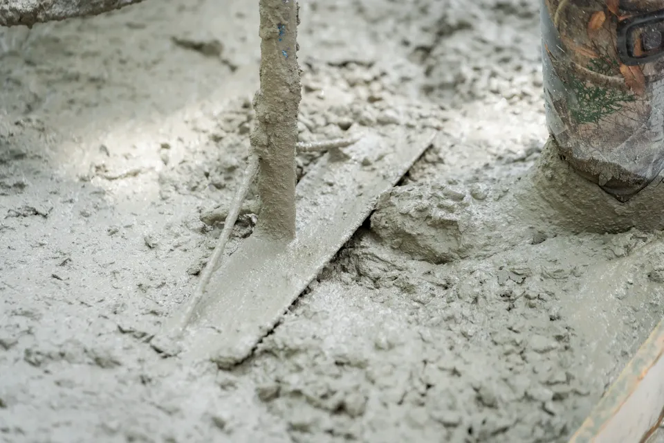 Wet concrete worked over rebar during a sidewalk pour.