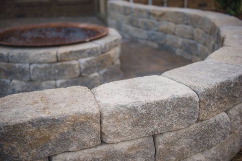 Curved stone wall and fire feature on a commercial hardscape patio.